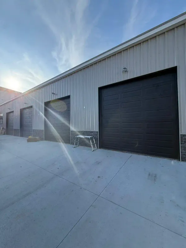 Large dark commercial garage door on metal frame industrial building