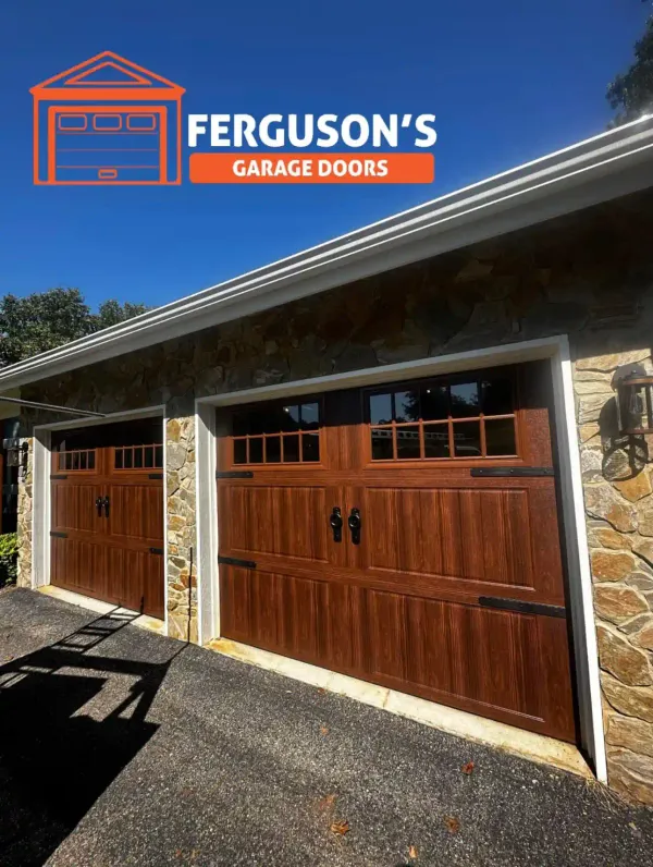 Warm wood carriage-style garage doors on stone ranch home
